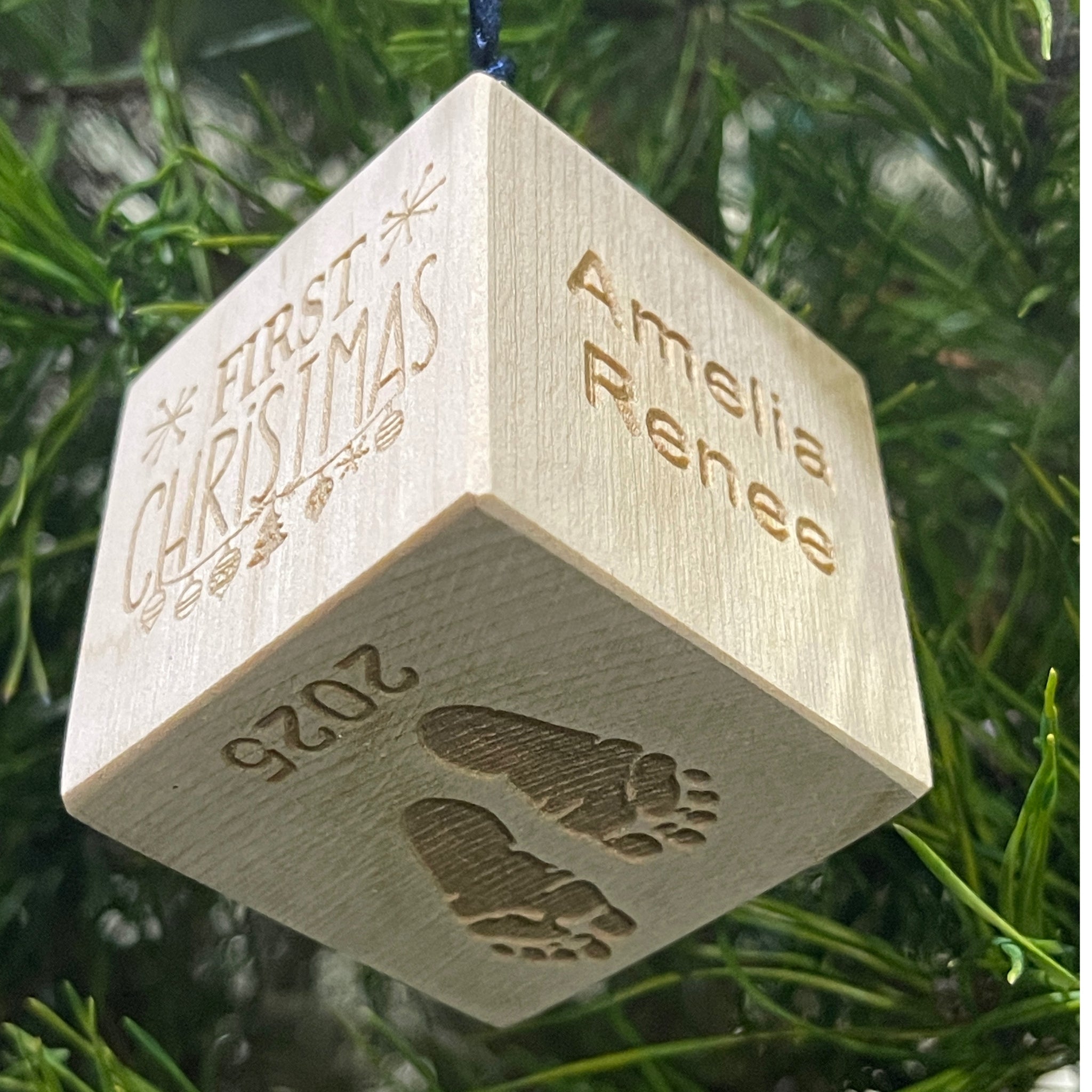 Personalized wooden baby block ornament with snowflake design held in hand