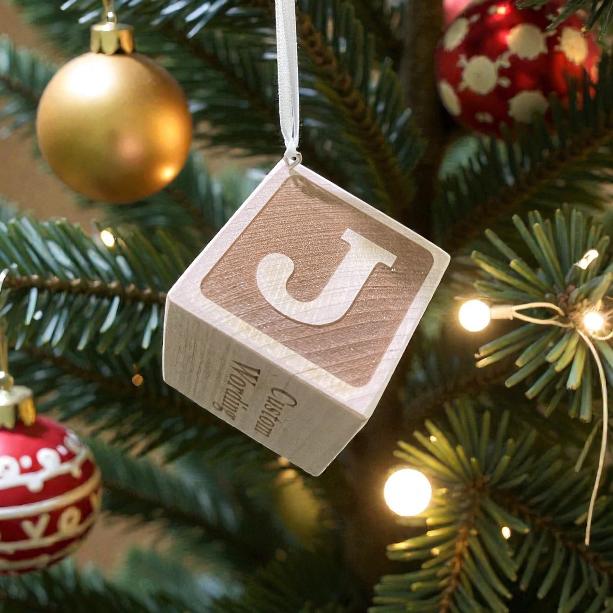 Close-up of engraved wooden baby block ornament with custom initial