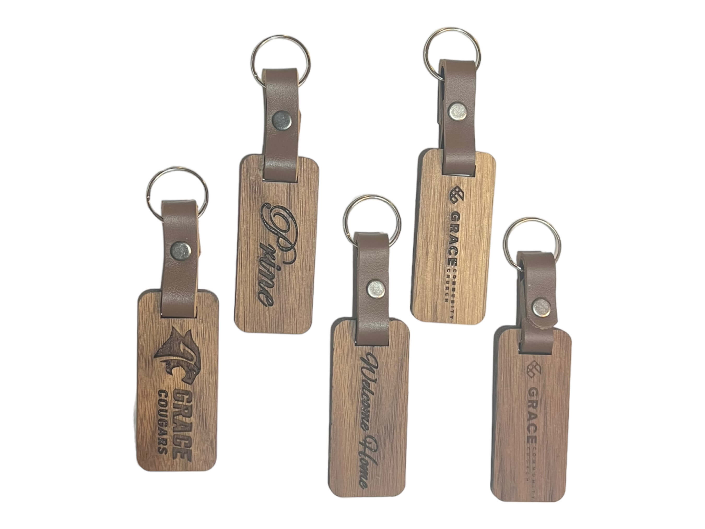 photo of five of our walnut keychains on a white background. see more at SawyerCustomCrafts.Com