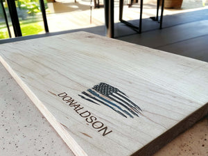 Detailed laser engraving of a distressed thin blue line flag on a maple cutting board