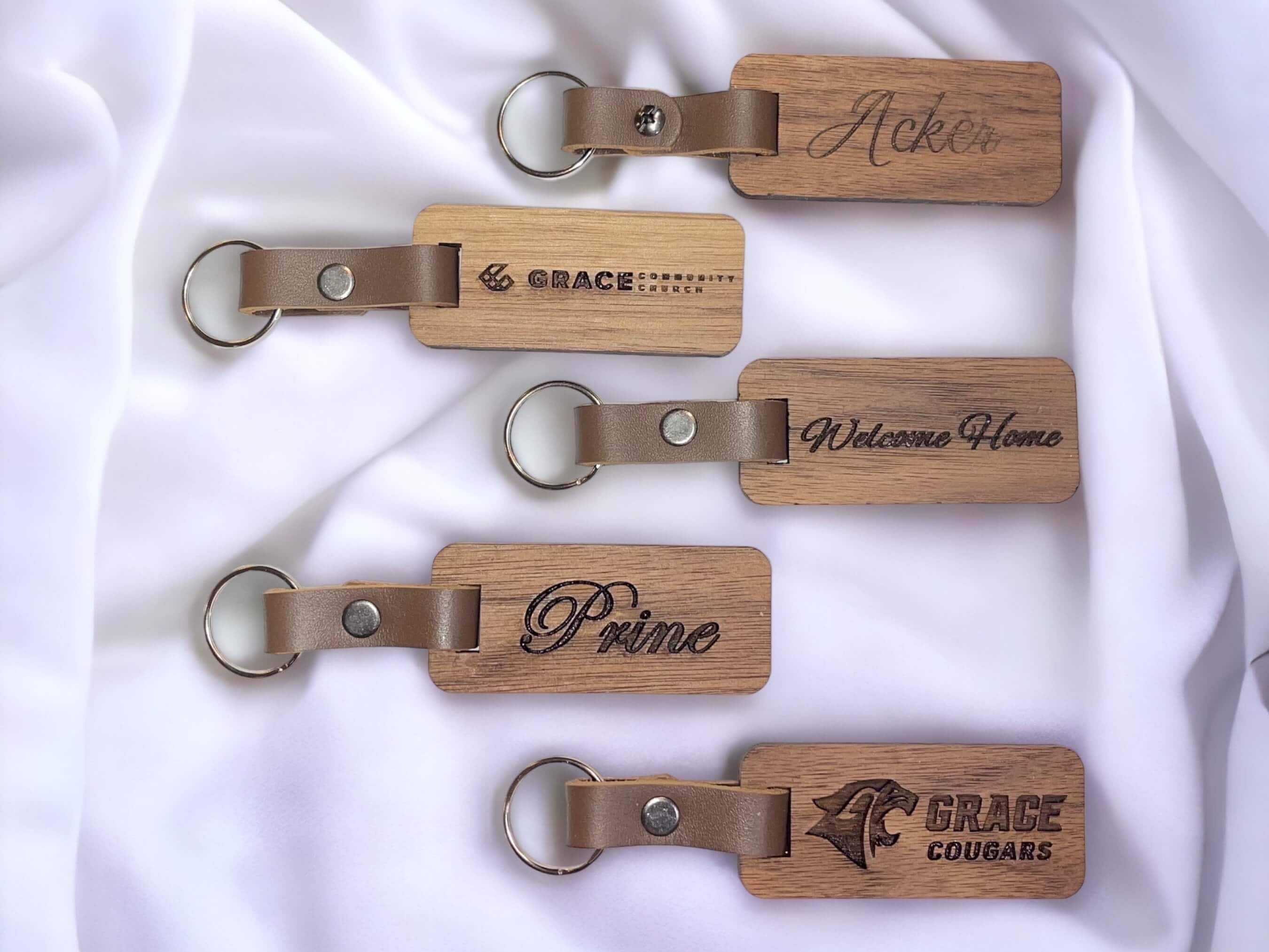 Photo showing five of our custom laser engraved walnut keychains. SawyerCustomCrafts.Com