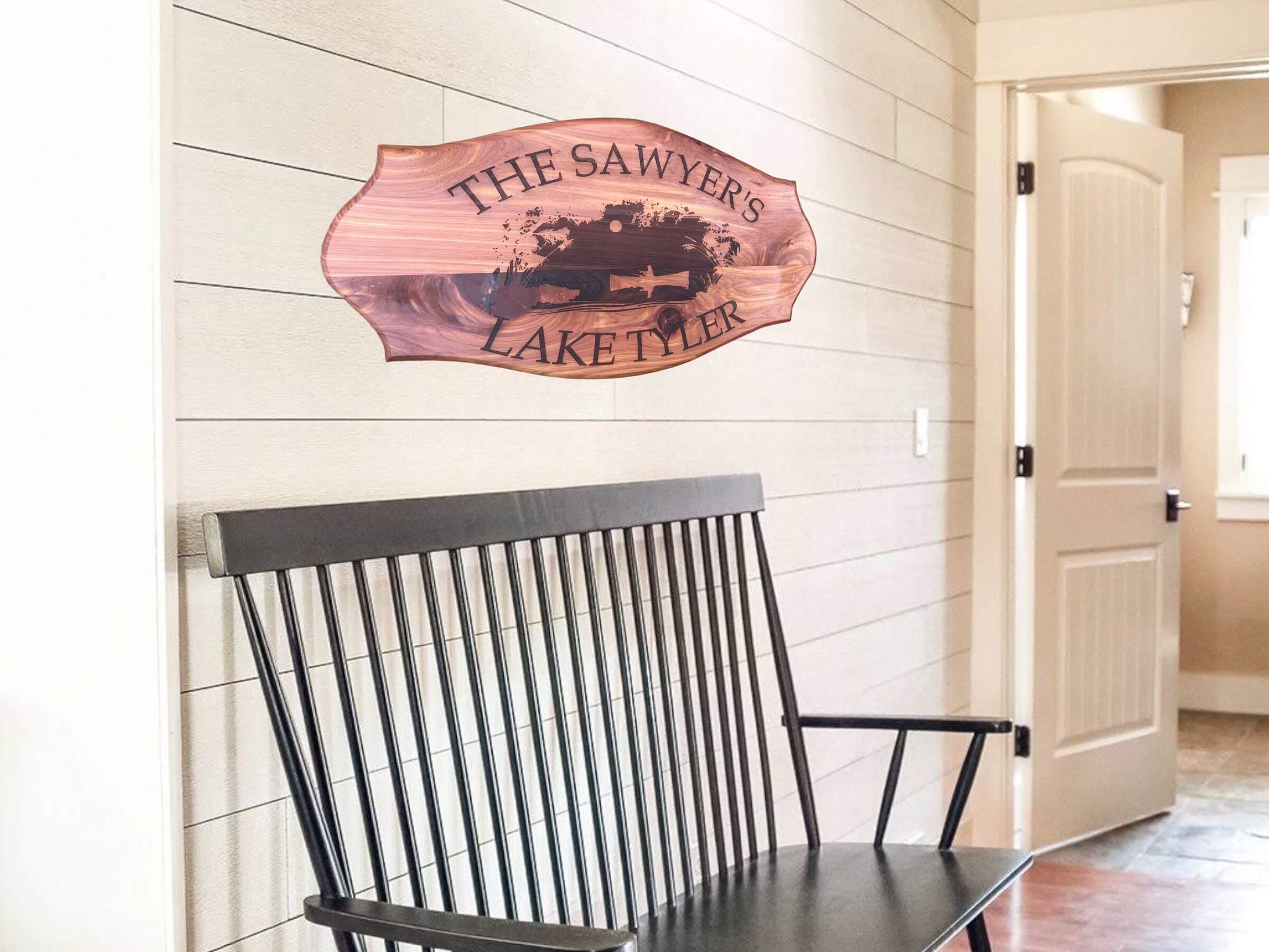 Rustic Cedar Lake House Sign with Customization" Description: A rustic lake house sign carved from cedar wood. The center of the sign showcases a laser-engraved image of a man fishing in a small boat. Customize it with your family name and lake name.