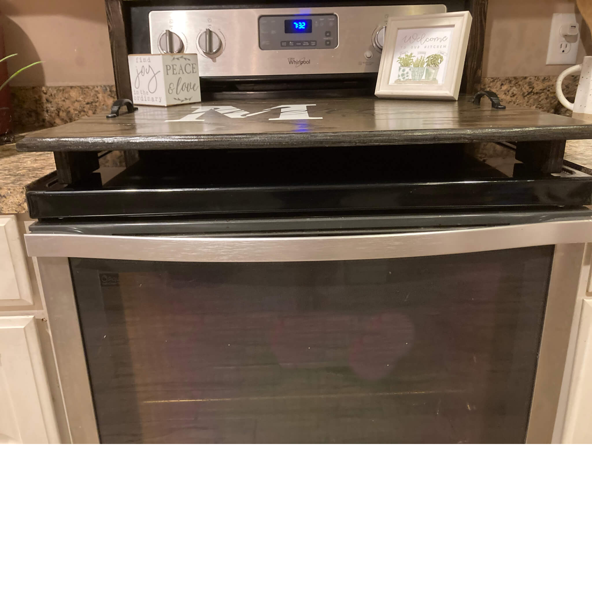 This is a view showing the raise of the Farm house stove top cover. It shows that the board has wooden feet which lift the cover up off the surface of the  stove top. 